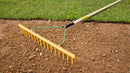 Chelwood® 16P® polypropylene rake on soil beside a lawn
